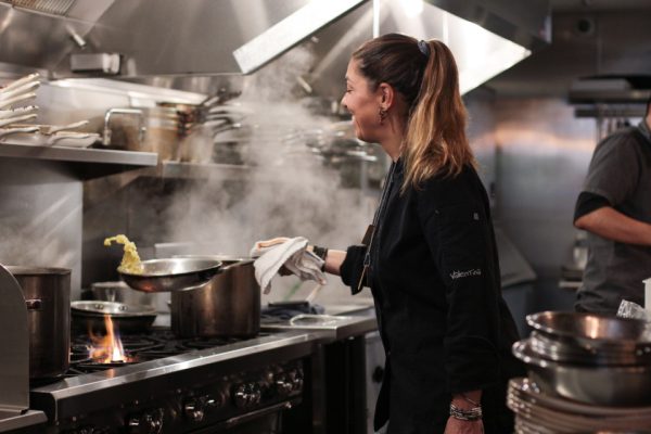 Valentina Guolo, chef cooking in restaurant kitchen
